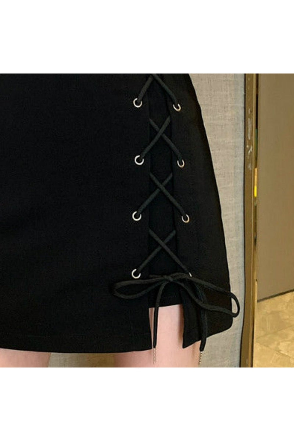 Stylish black lace-up mini skirt enhances outfit.