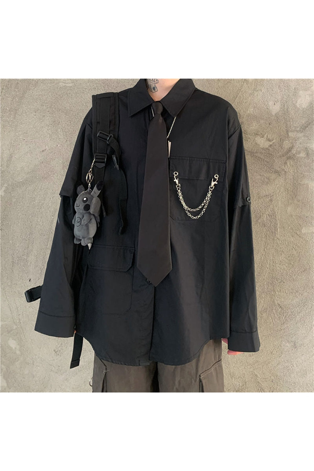 Oversized black shirt with chain tie detail.