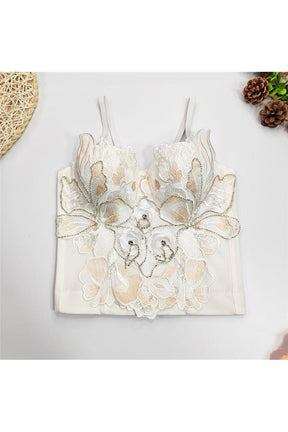 Elegant white camisole with intricate beading detail.