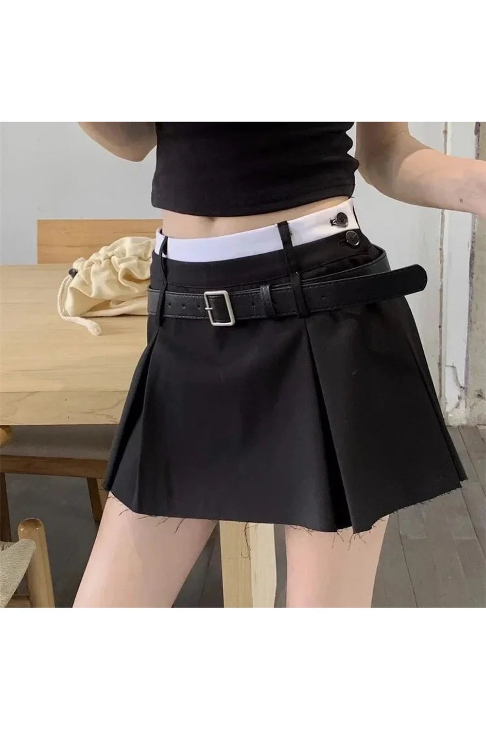 Stylish black pleated mini skirt with belt detailing.