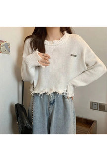 Soft white sweater with frayed edges.