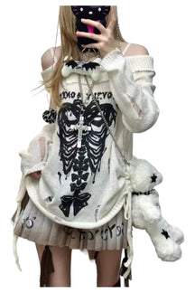 Off-shoulder white sweater with gothic skull motif.