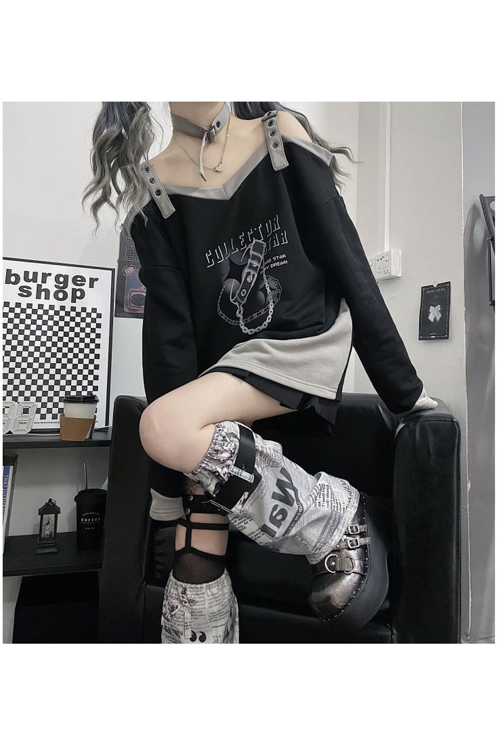 Stylish black off-shoulder sweatshirt with grunge aesthetic.