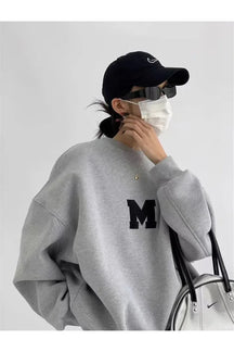 Oversized gray sweatshirt with monochrome varsity design.