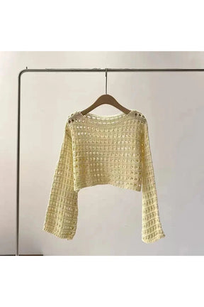 Beige open-knit sweater lends cozy elegance. Cozy.