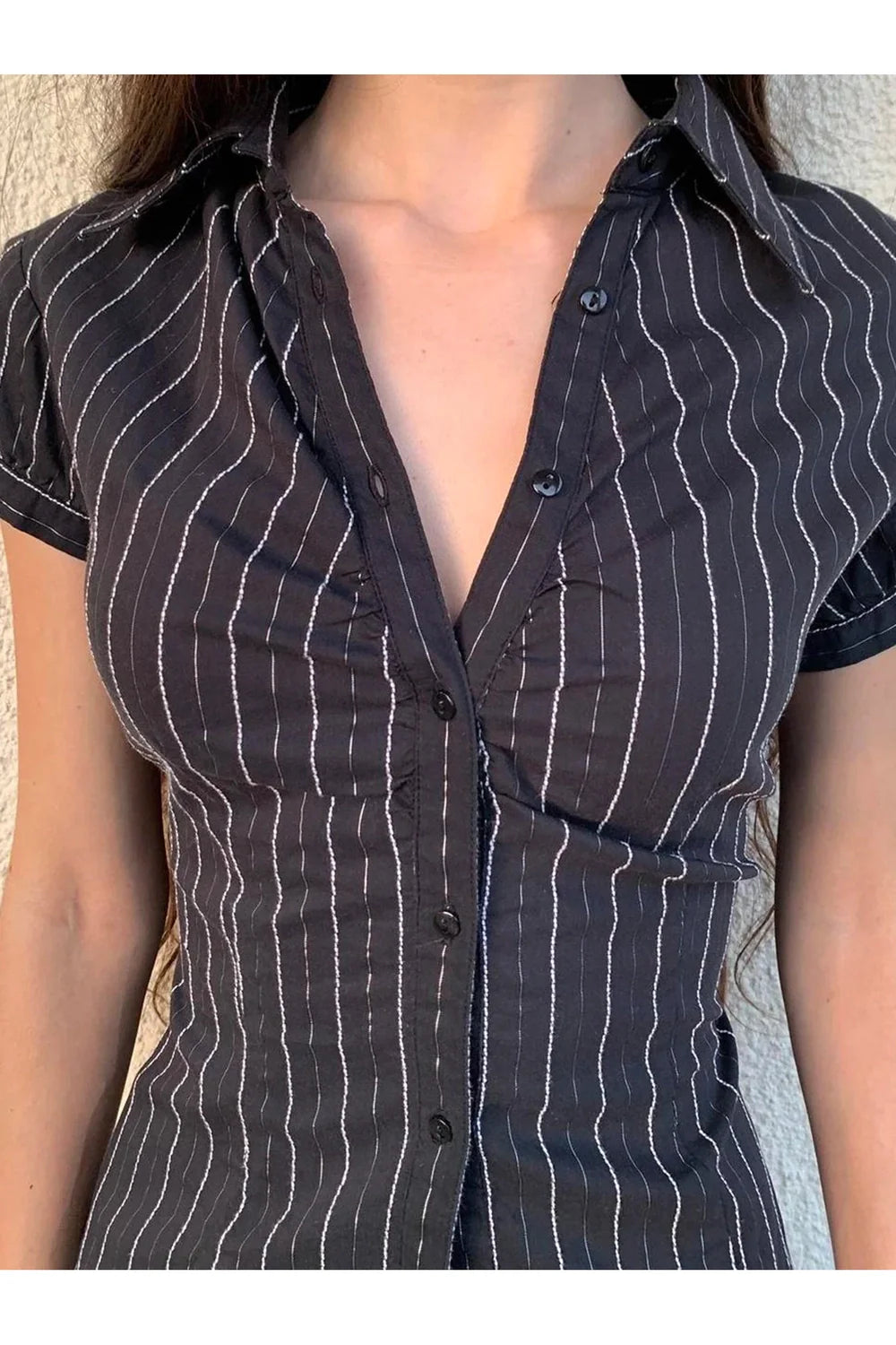 Black pinstripe fitted button-up blouse exudes sophistication.