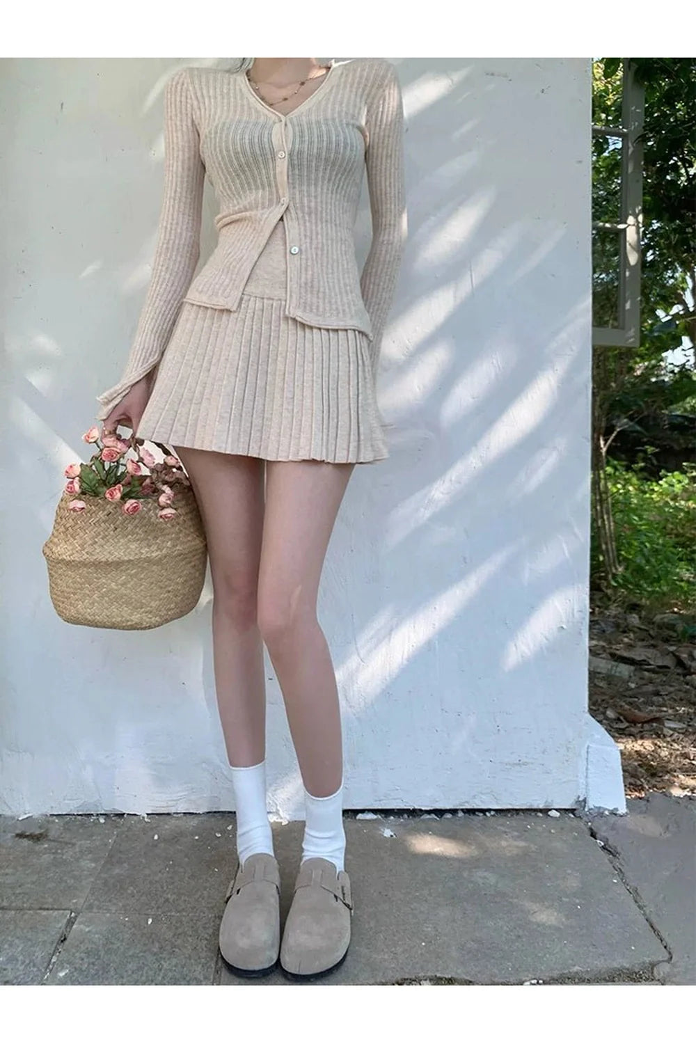 Stylish apricot ribbed cardigan and pleated skirt.