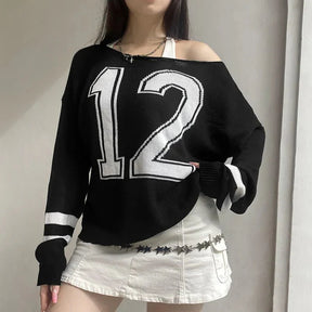 Off-shoulder black sweater with varsity-inspired details.